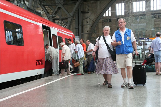 Mitarbeiter der Bahnhofsmission begleitet eine blinde Frau